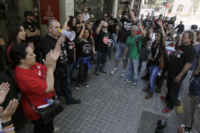 A protester delivers a speech through a megaphone during a demonstration outside the central employment office in Valencia